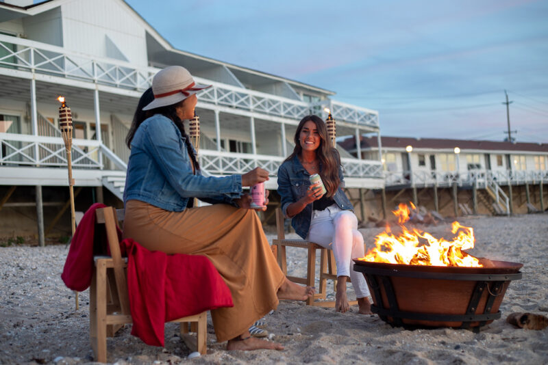 Friends hanging out at firepit on beach