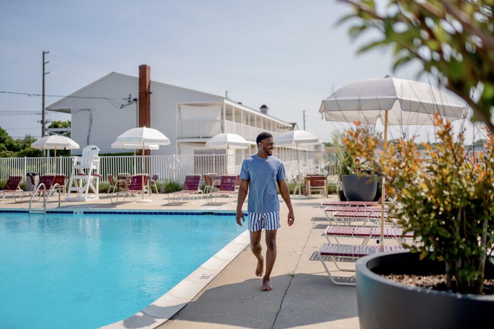 A man walking by the pools edge at Sound View Greenport in summer.