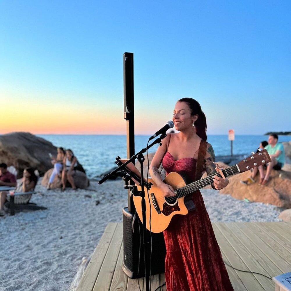 A woman singing on the beach at Low Tide Bar.