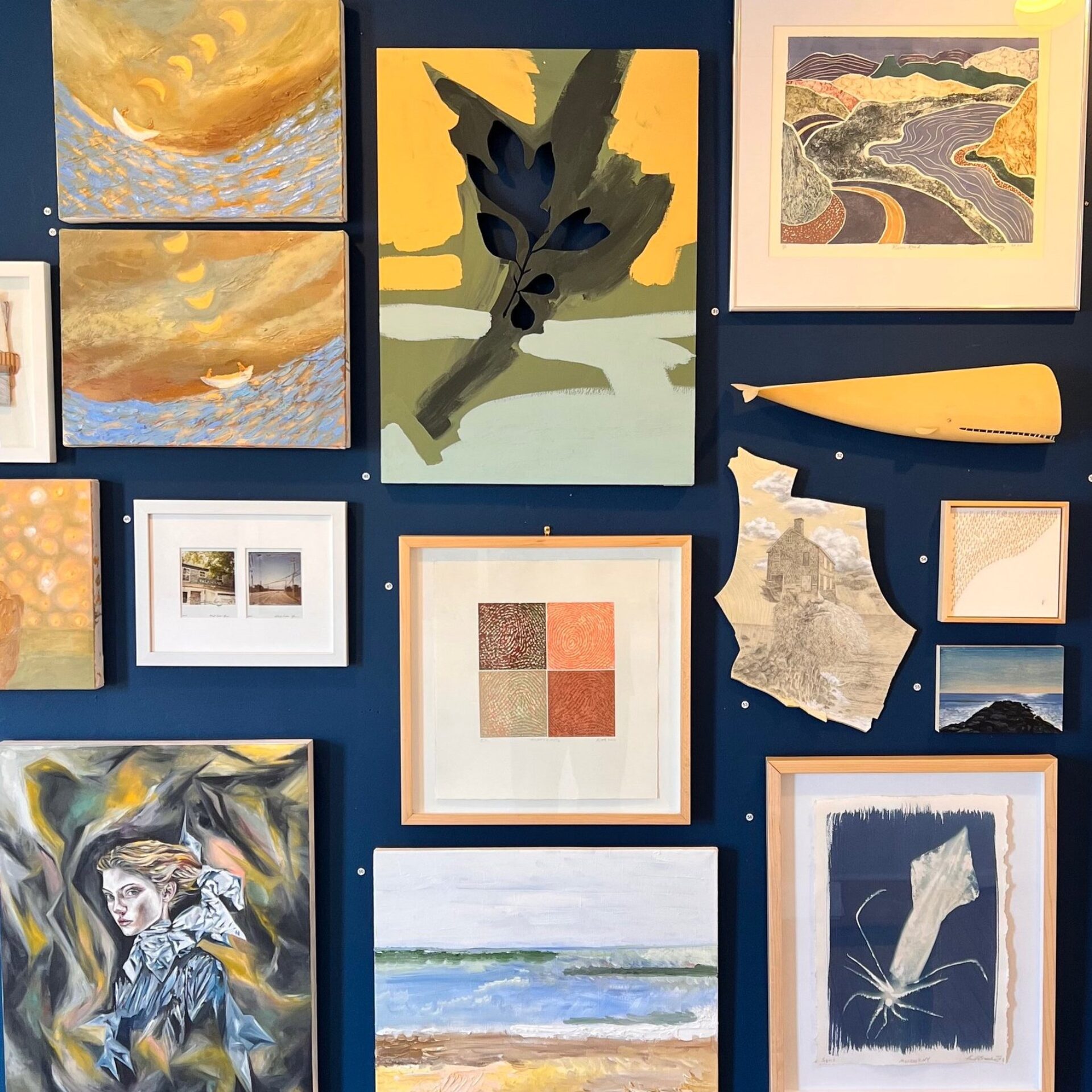 A gallery wall of paintings and sculptures at North Fork Art Collective (NFAC) in Greenport, New York.