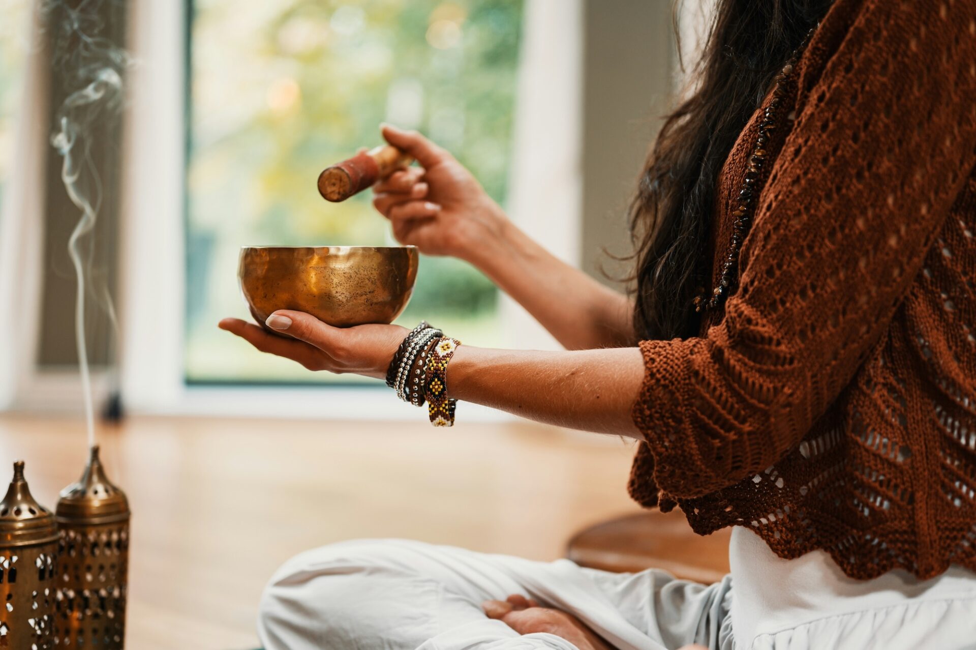 A woman practicing a sound bath with incense.