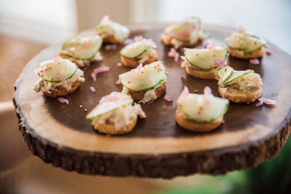 Crab Salad Canape with cucumbers on a wood tray.