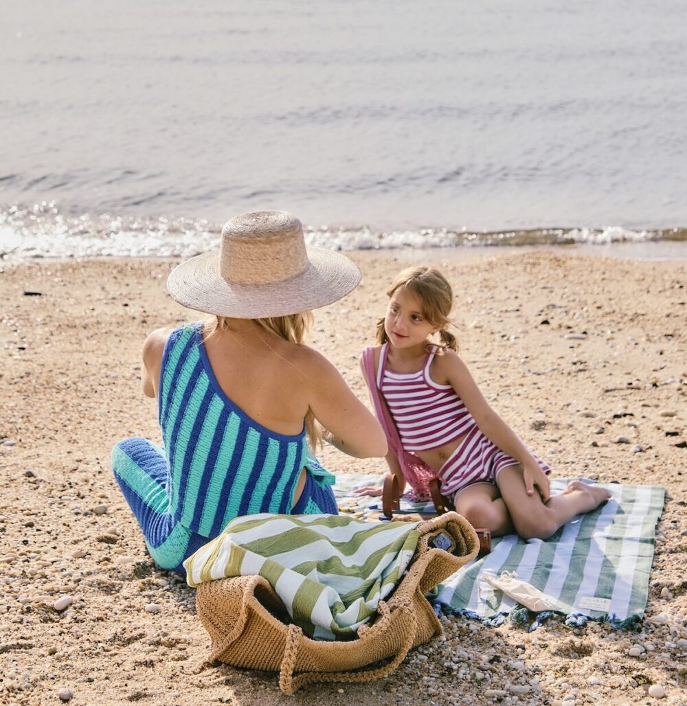 A mother and daughter playing by the beach.