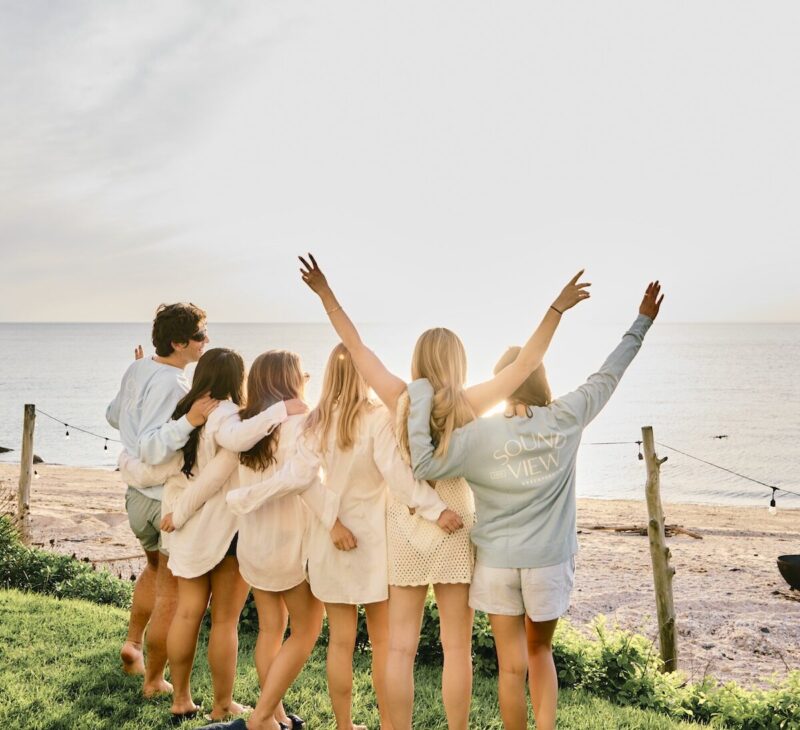 A group of friends looking out at the sunset.