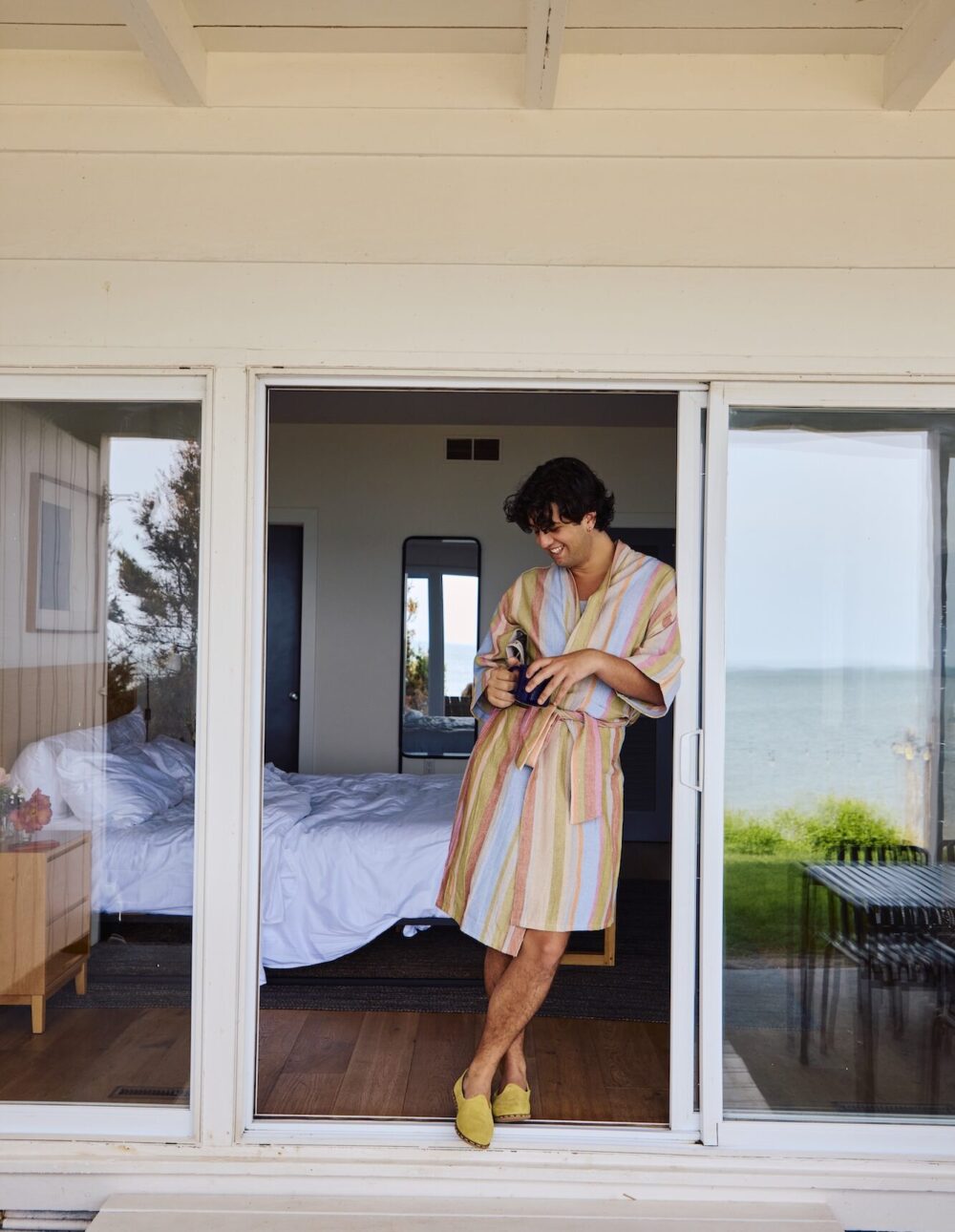 A man drinking coffee on the patio off is bedroom at Sound View Greenport.