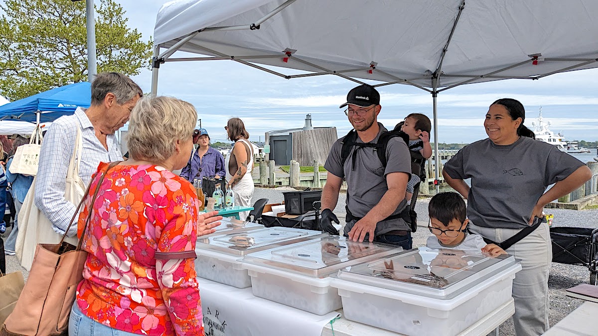 A family buying produce at a local farmers market.
