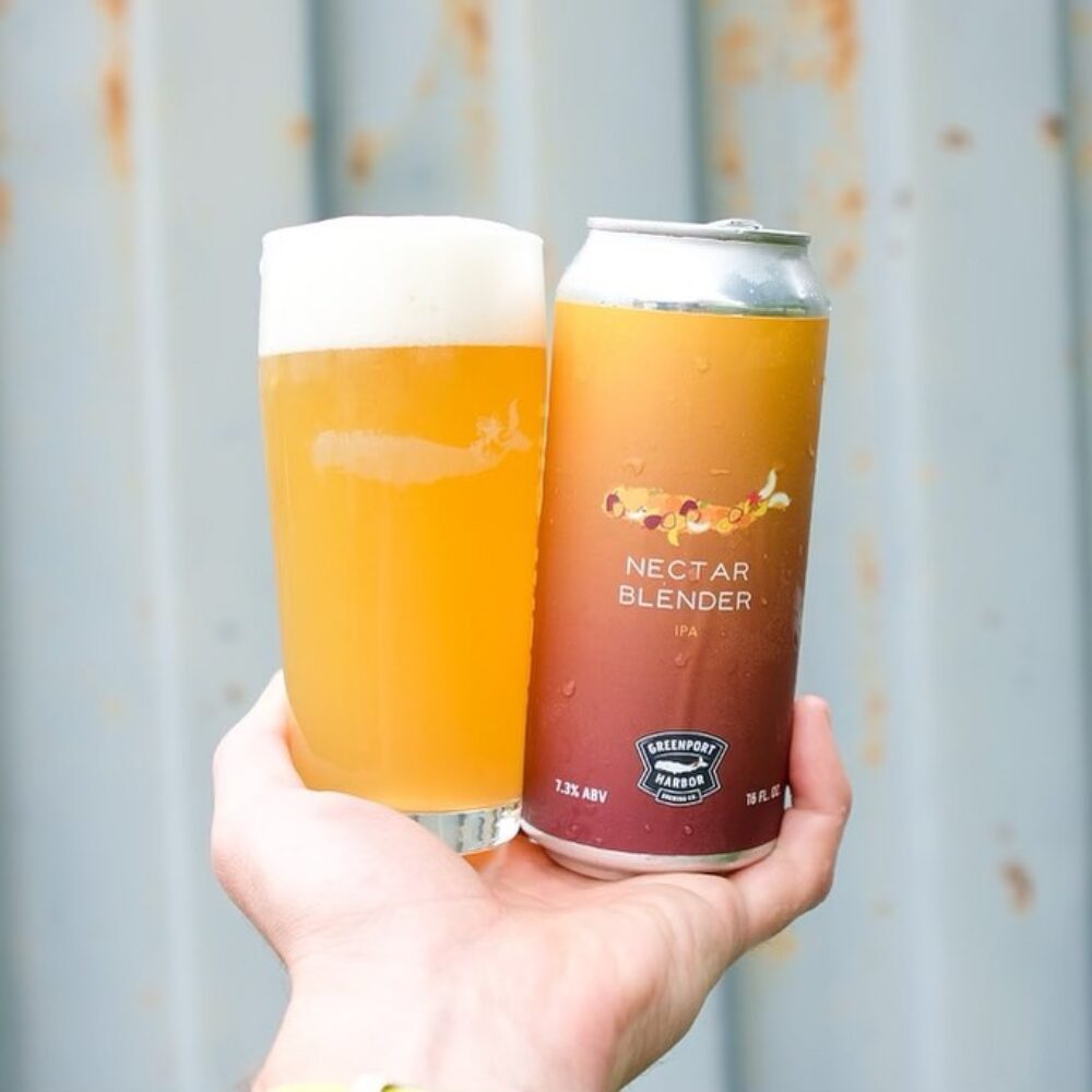 A beer in a glass, and beer can in one hand.