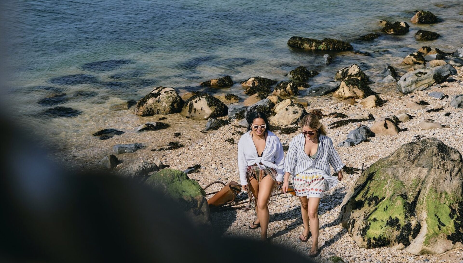 Two women walking along the beach.