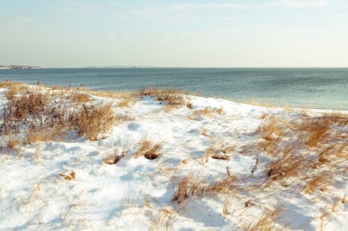 Snow cover dunes overlooking the water in Greenport, NY.