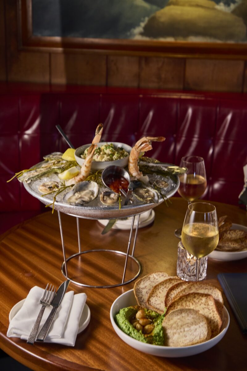 A seafood tower and glasses of white wine.