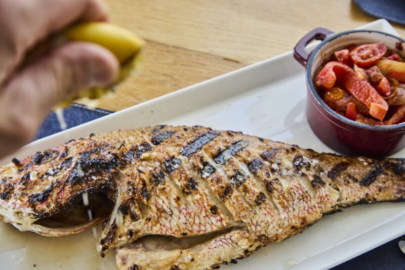 A grilled fish with a lemon squeeze.