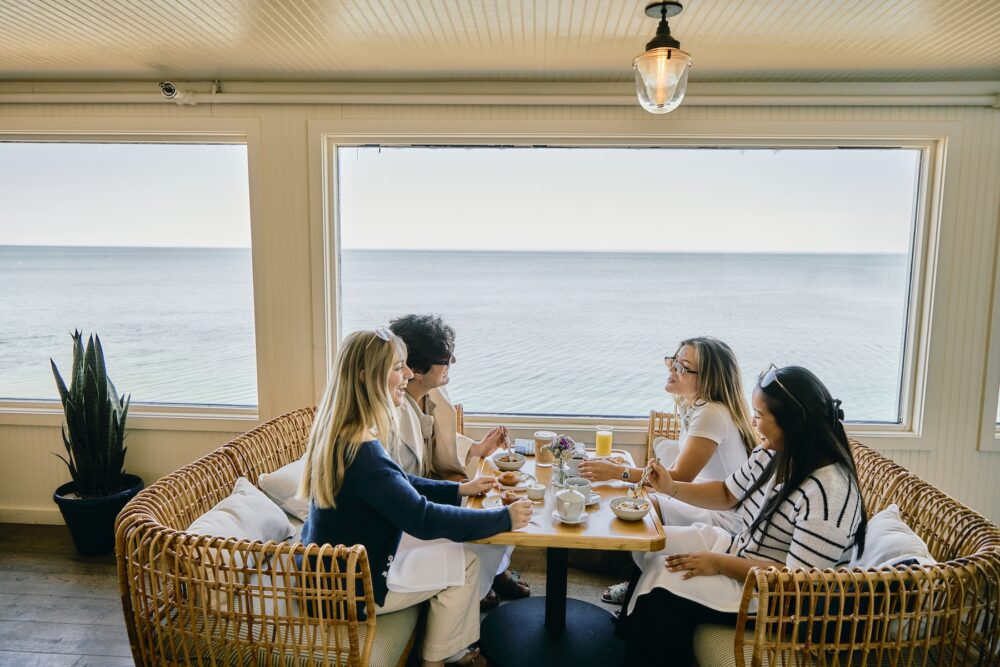 A group of friends having breakfast by the water.