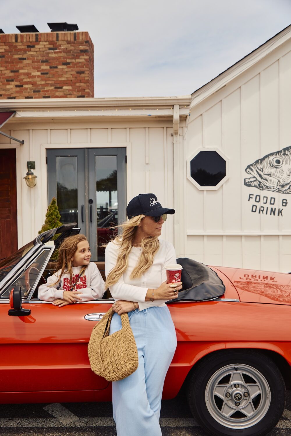 A mother and daughter leaning up against a car outside of the Sound View Greenport entrance.