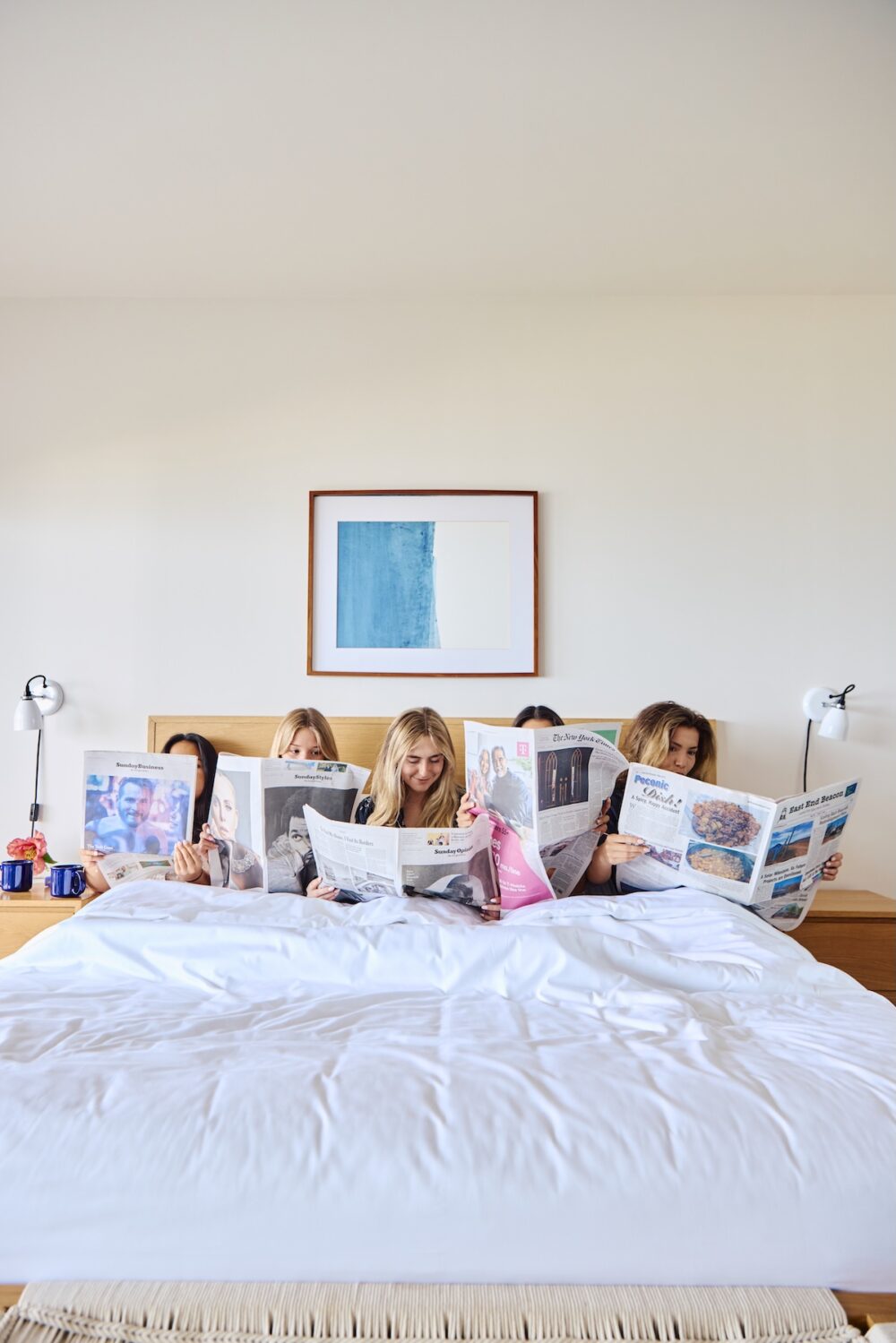 Friends in bed reading the newspaper at Sound View Greenport.
