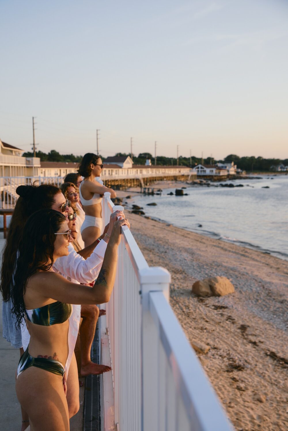 A group of people looking out at the sunset over Sound View Greenport.