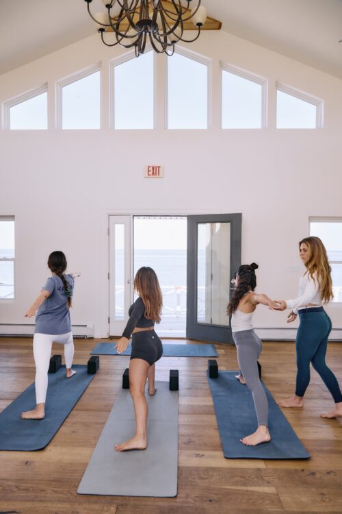 A group of women practicing yoga in the Gathering Room at Sound View Greenport.