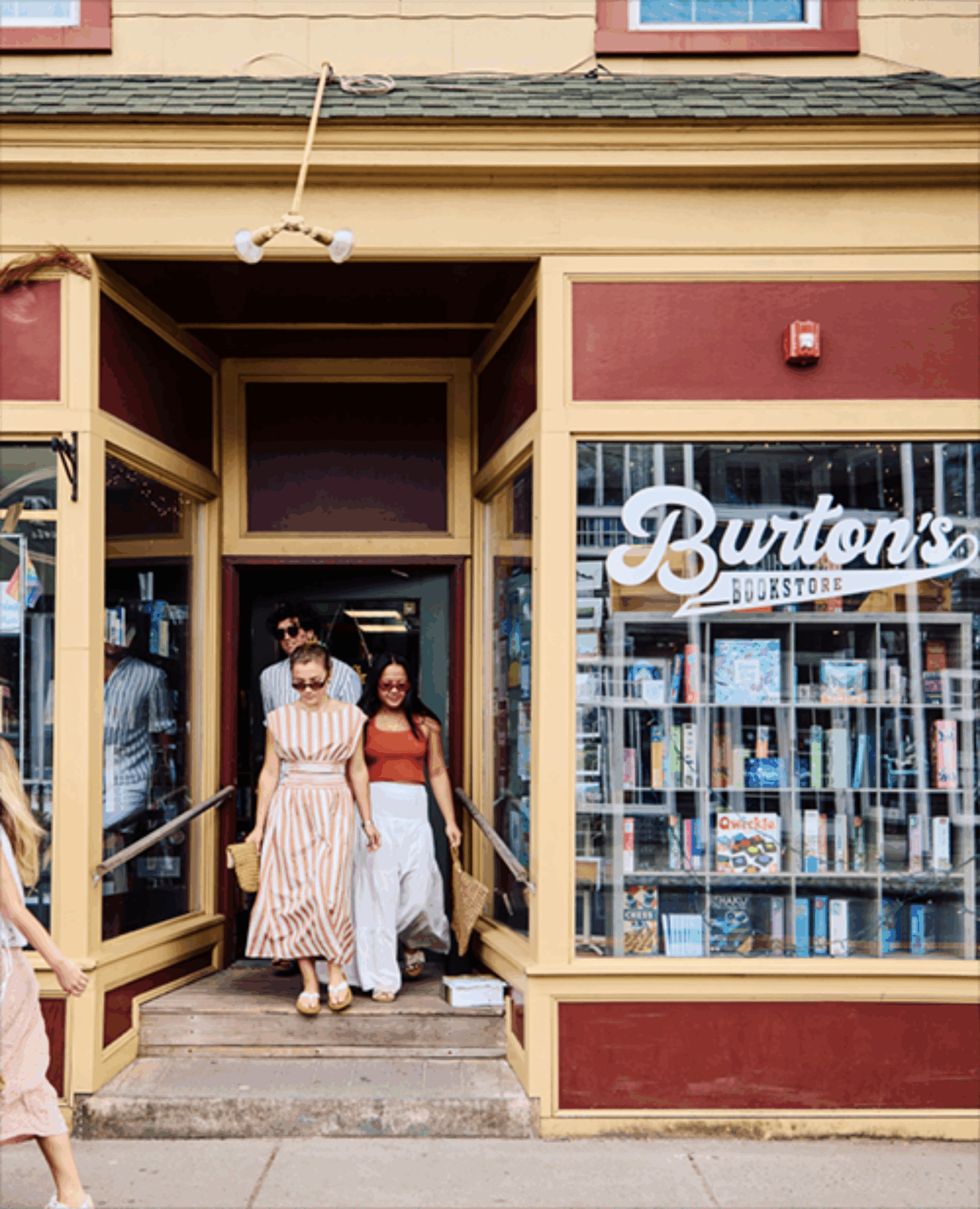 A group of people walking out of Burton's Bookshop in Greenport, NY.